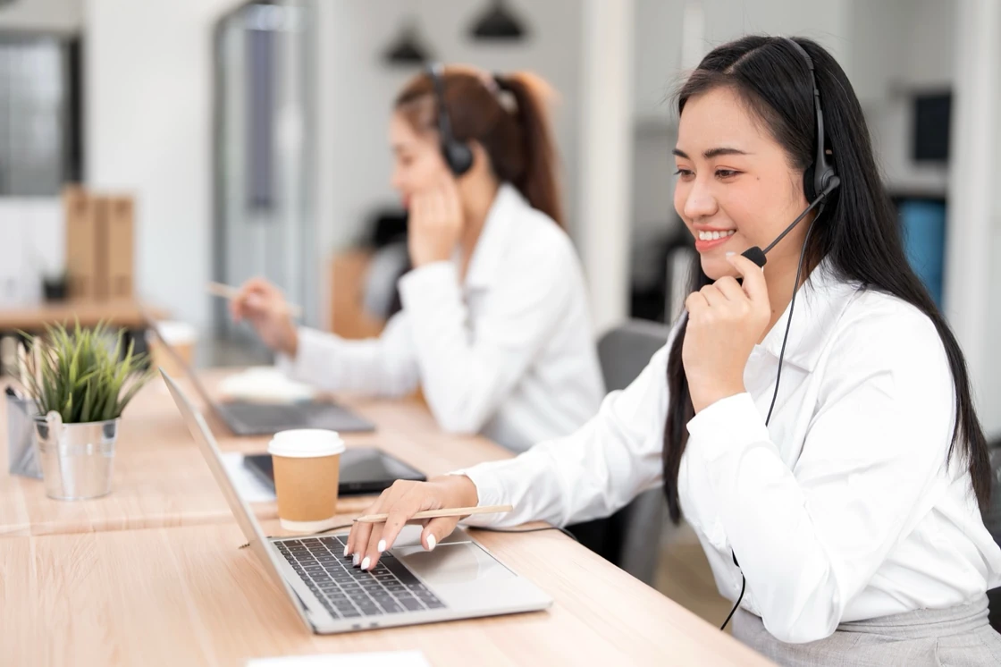 Customer support agent with headset at laptop