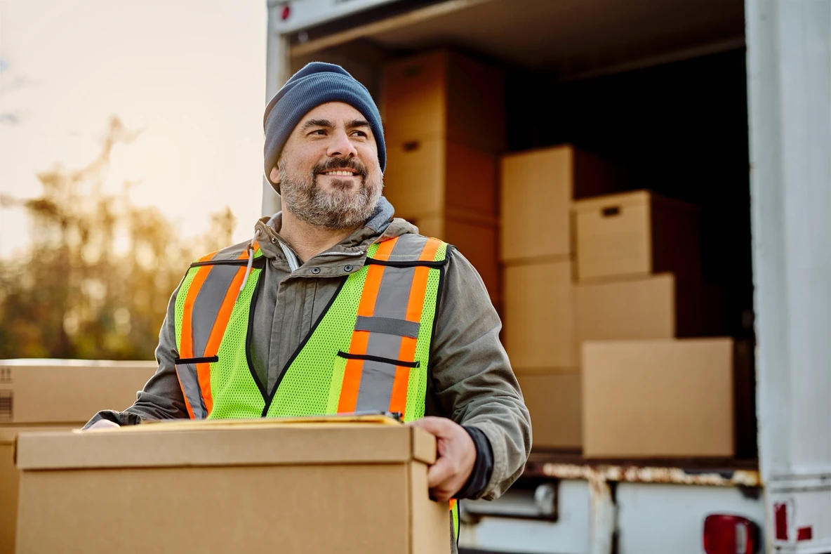 A delivery driver loading parcels at a depot